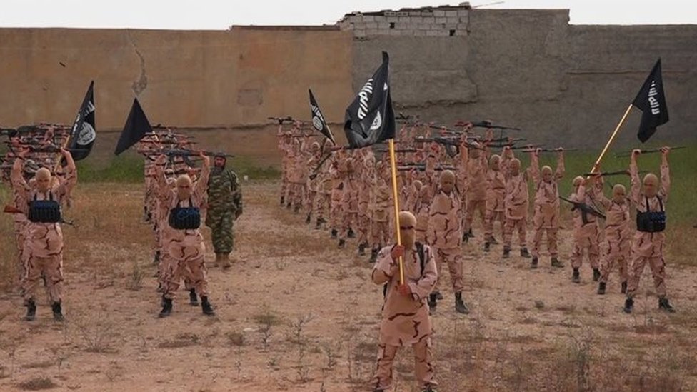 Мальчики, известные как «львята», держат винтовки и флаги группировки Исламское государство в тренировочном лагере недалеко от Тал Афара, Ирак