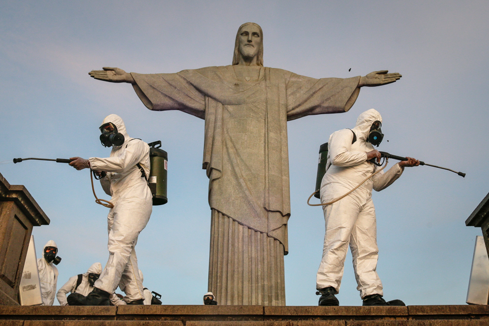 Military personnel disinfect the area surrounding the statue of Christ the Redeemer