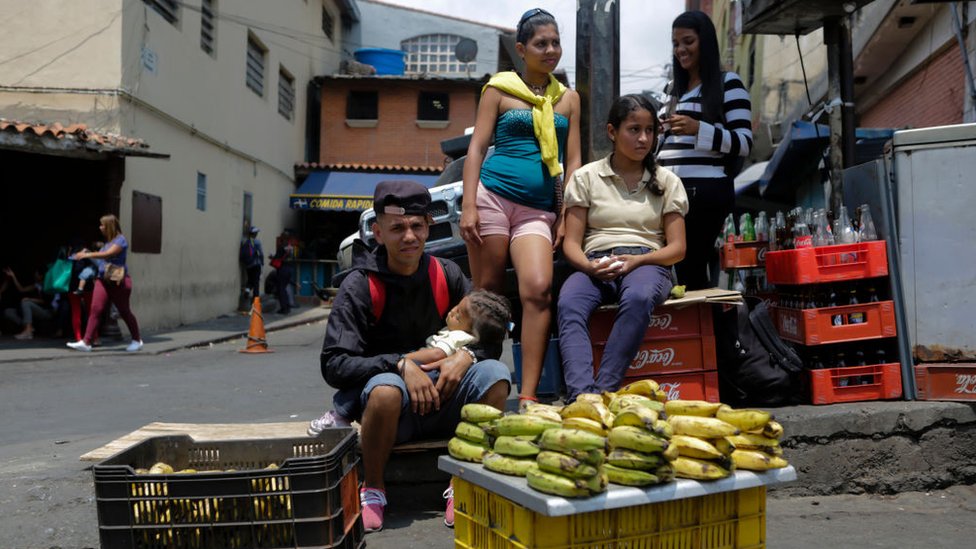 Personas vendiendo alimentos en la calle en Venezuela.