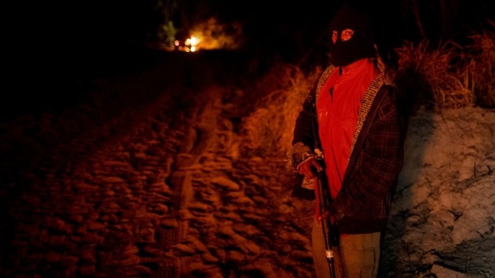Пауло Паулино Гуахахара держит пистолет во время розыска нелегальных лесорубов в сентябре