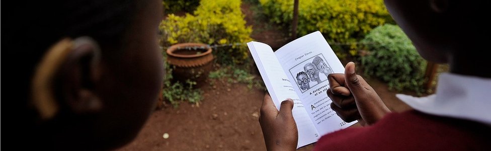 Двое учеников читают книгу в Кении