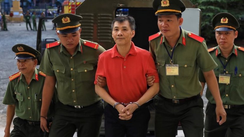 Майкл Фыонг Минь Нгуен (в центре) сопровождается вьетнамской полицией в суд в Хошимине. Фото: 24 июня 2019 г.