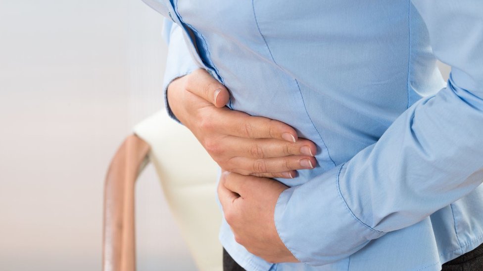 Existen dos tipos de incontinencia fecal: de urgencia y pasiva. Una mujer se toca el estómago