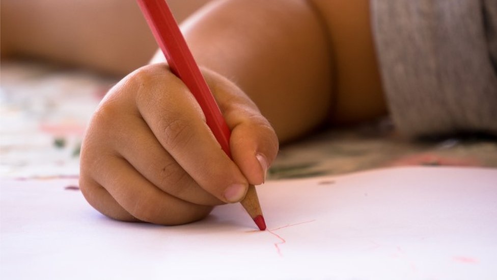La escritura a mano transmite mucho más que el simple contenido del mensaje. Un niño haciendo garabatos en un papel con un creyón rojo
