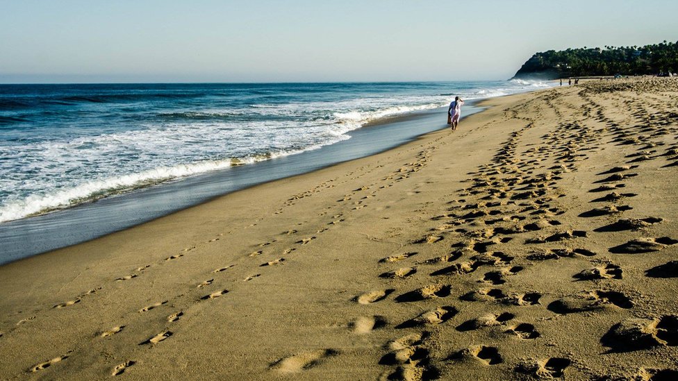 Hombre caminando en la playa