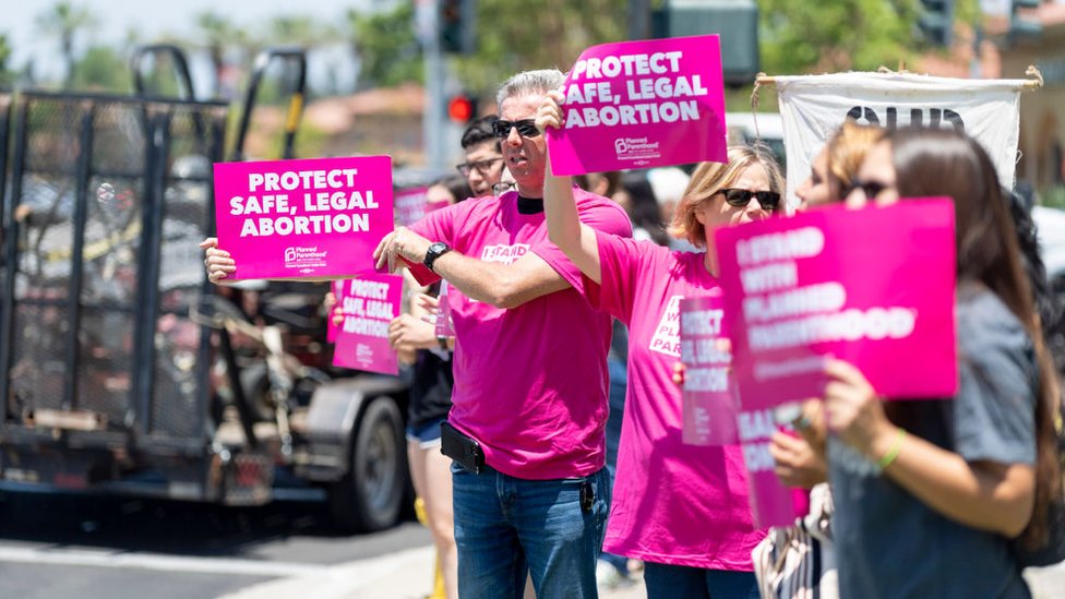 Manifestantes sostienen carteles en defensa del aborto legal y seguro en en Irvine, California en junio de 2019.