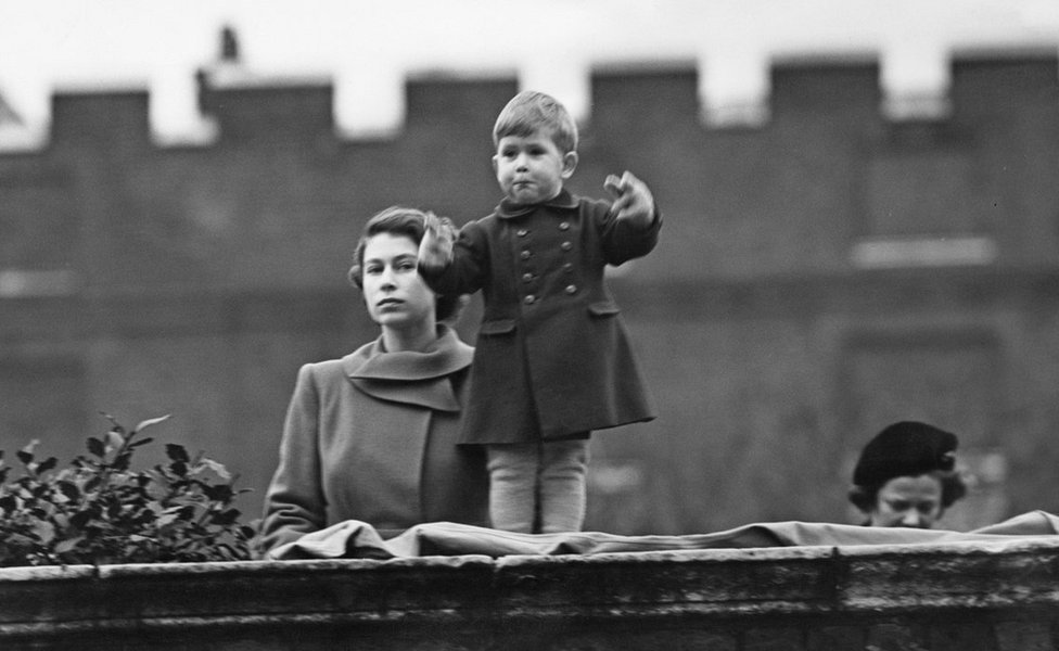Princess Elizabeth (later Queen Elizabeth II), left, and Prince Charles watching a procession, during the visit of Queen Juliana of the Netherlands, from the wall of Clarence House, London, 22nd November 1950.
