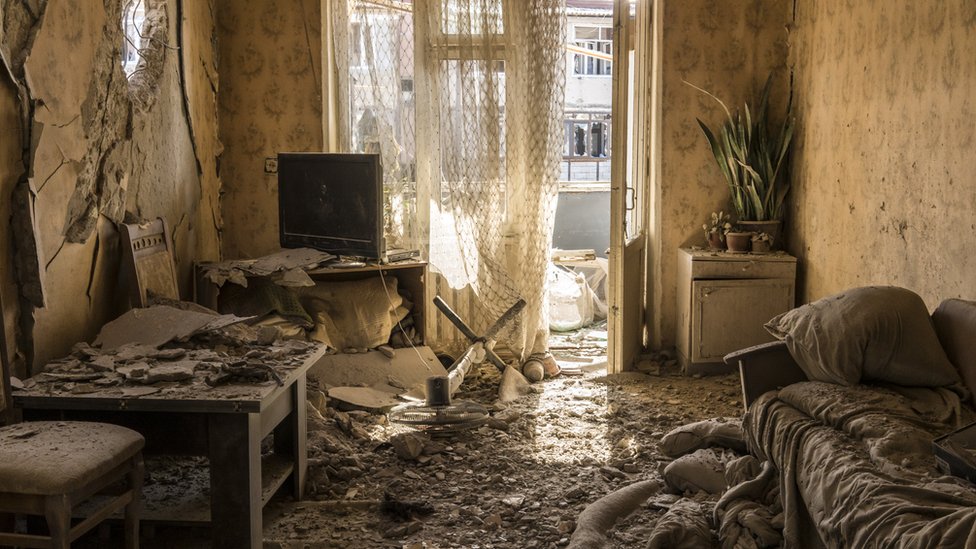 Dirt and debris covers the floor in an apartment on the top floor of a building that was shelled in Nagorno-Karabakh