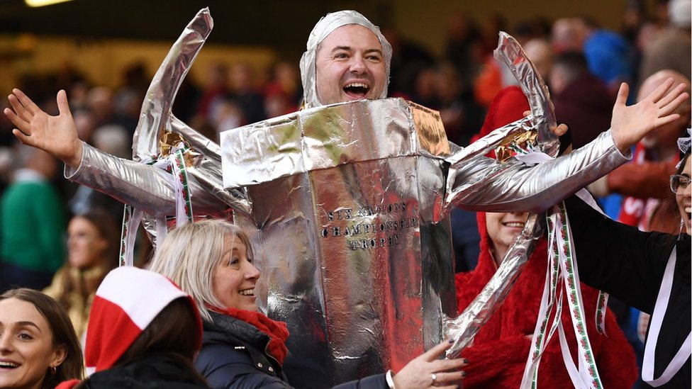 Болельщик Уэльса празднует победу в турнире Большого шлема Уэльса, одетый как трофей Шести Наций