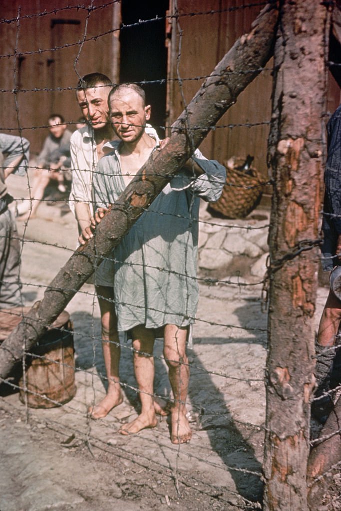 Foto ilustrasi: Dua tawanan perang Perang Dunia II menatap melalui pagar kawat berduri di Kamp Konsentrasi Buchenwald di dekat Weimar, Jerman, 1945.