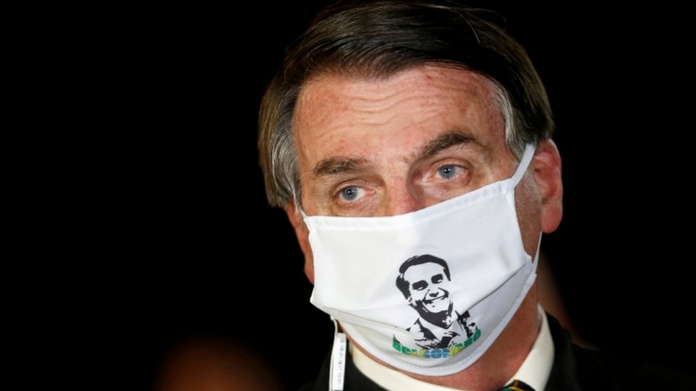 President Jair Bolsonaro speaks with journalists while wearing a protective face mask as he arrives at Alvorada Palace, amid the coronavirus disease (COVID-19) outbreak, in Brasilia, Brazil, May 22, 2020