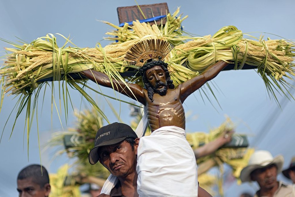Peregrino cargando una cruz con Cristo en El Salvador.