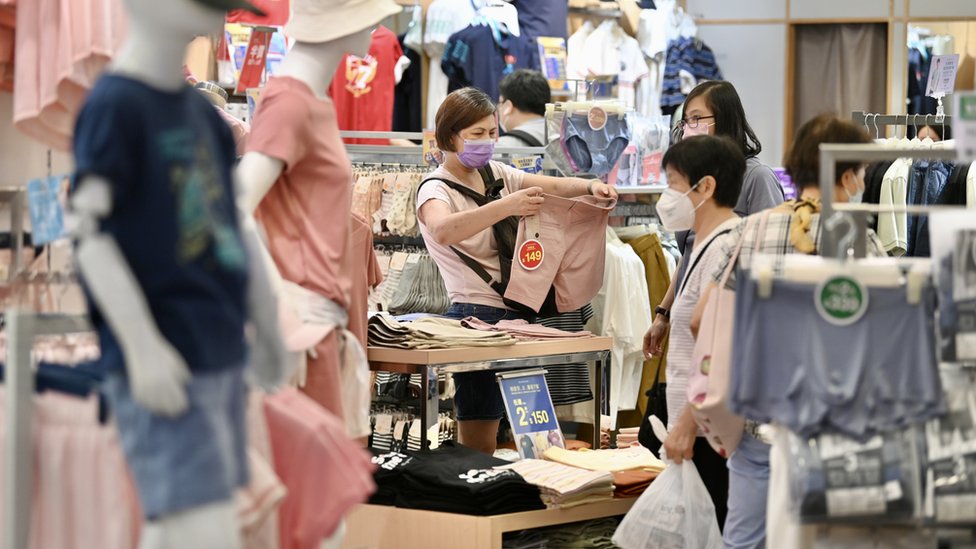 香港某服裝店市民在選購衣服（中新社圖片4/8/2022）