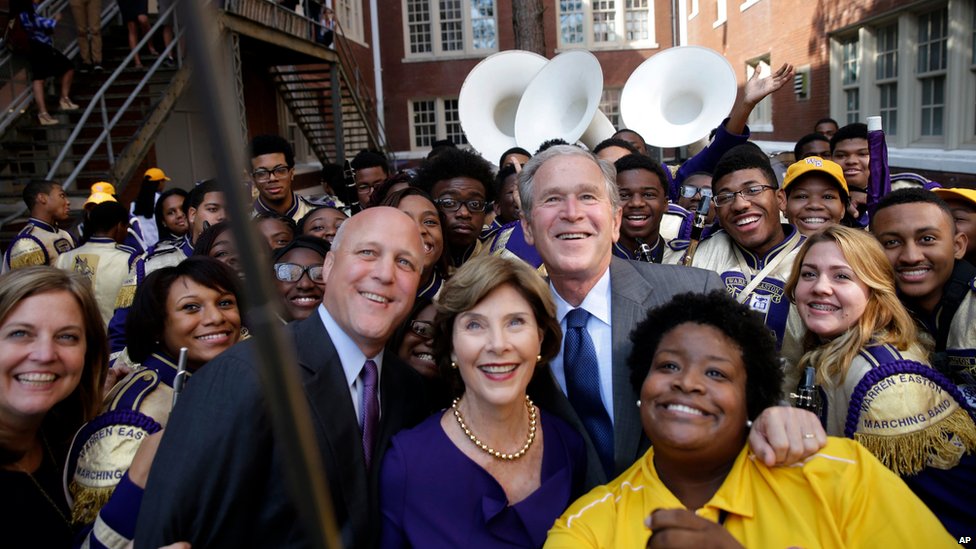 Бывший президент Джордж Буш позирует для "селфи" с бывшей первой леди Лорой Буш, руководителем оркестра Асией Мухаймин (справа) и мэром Нового Орлеана Митчем Ландриу (слева) в средней школе Чартерного Уоррена Истона в Новом Орлеане 28 августа | ||