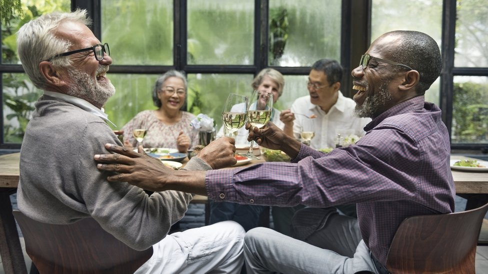 Grupo de personas mayores comiendo y riendo