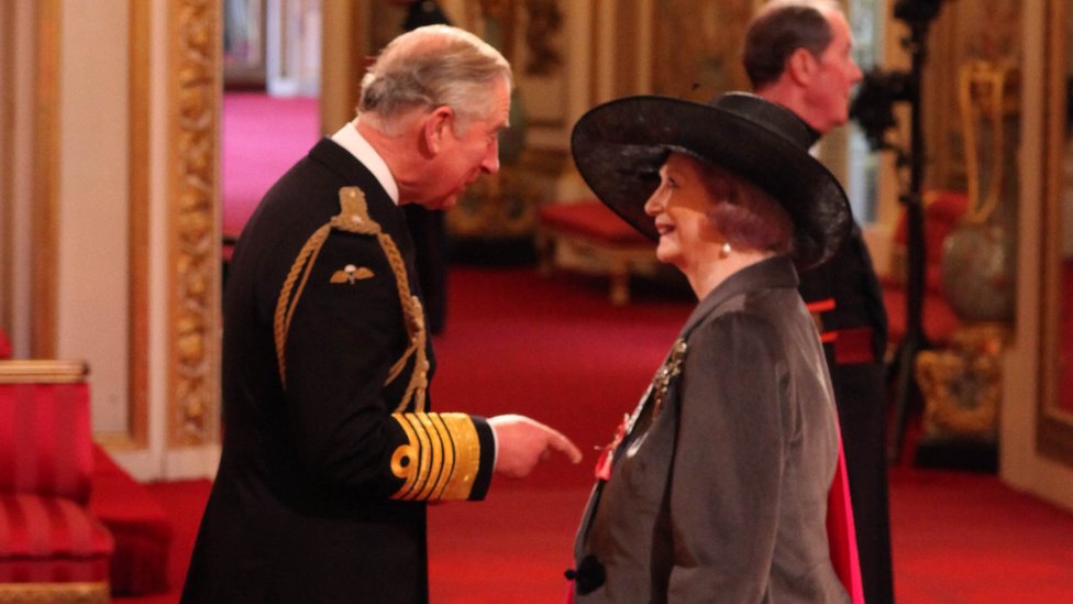 April Ashley onur ödülünü Buckingham Sarayı'nda Veliaht Prens Charles'ın elinden aldı.