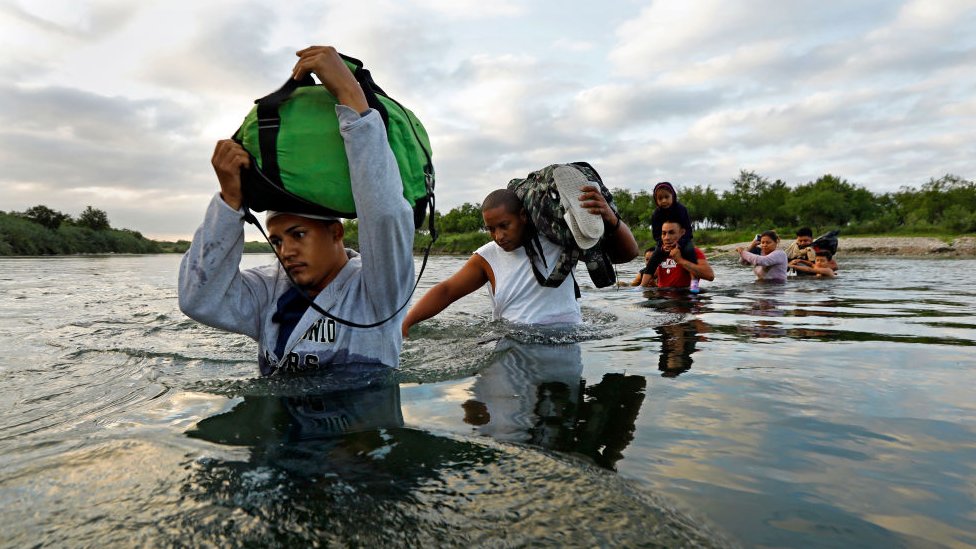 Un grupo de migrantes hondureños y cubanos cruzan el Río Bravo en la frontera entre EE.UU. y México.