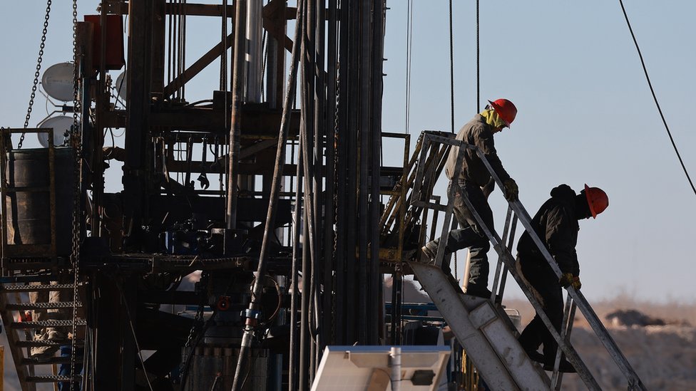 عمال يضعون أنبوب في الأرض لاستخراج النفط في حقل خليج برميان في تكساس