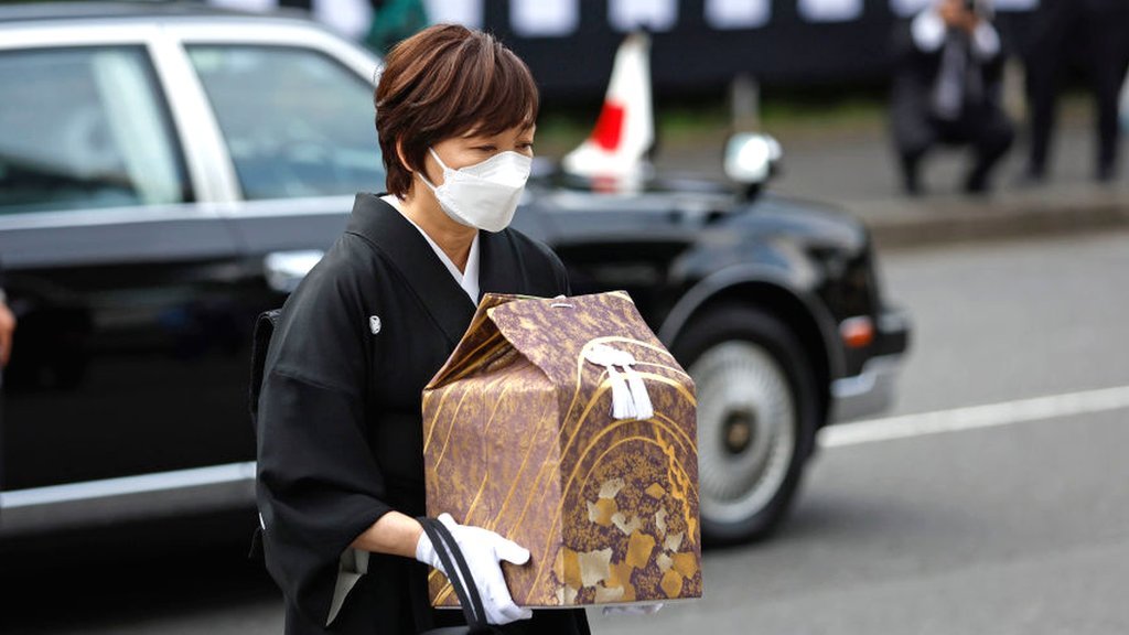 Akie Abe - abe's wife - carries his ashes