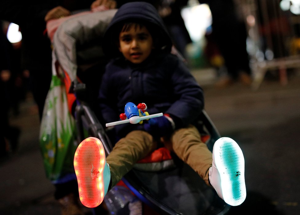 Мальчик показывает свои туфли с подсветкой во время празднования Дивали в Лестере
