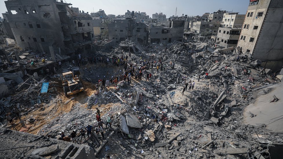فلسطينيون يبحثون عن ناجين وسط حطام أحد المباني في غزة