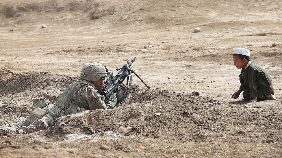 Un niño mira a un soldado del ejército estadounidense en Kandahar, Afganistán en 2014
