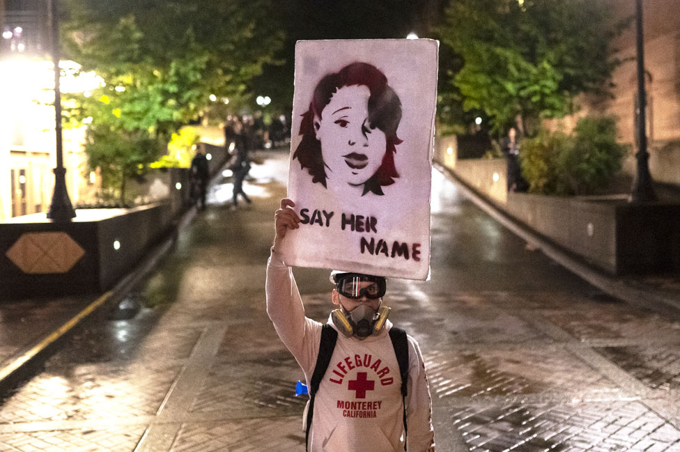 Протестующий держит фотографию Бреонны Тейлор