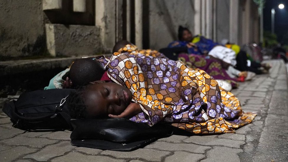 Congolese fleeing from Goma, Democratic Republic of Congo (DRC), sleep with their belongings on a street after the Nyiragongo volcano erupted near the border in Gisenyi, Rwanda, on 23 May 2021