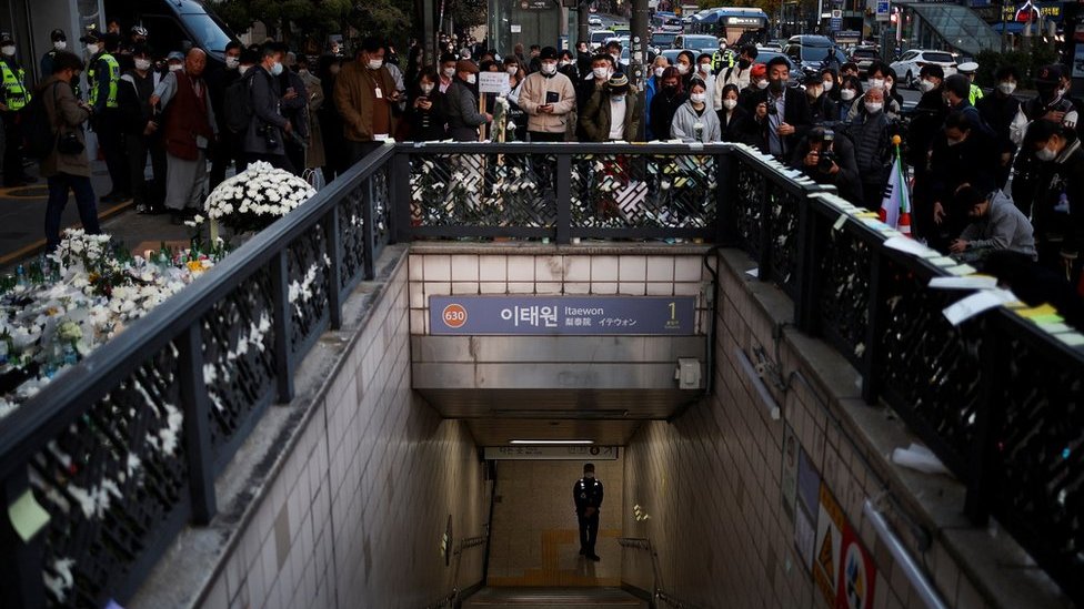 A police officer stands guard at the exit of a subway station as people gather to pay their respects following a crowd crush that happened during Halloween festivities, in Seoul, South Korea, November 1, 2022.