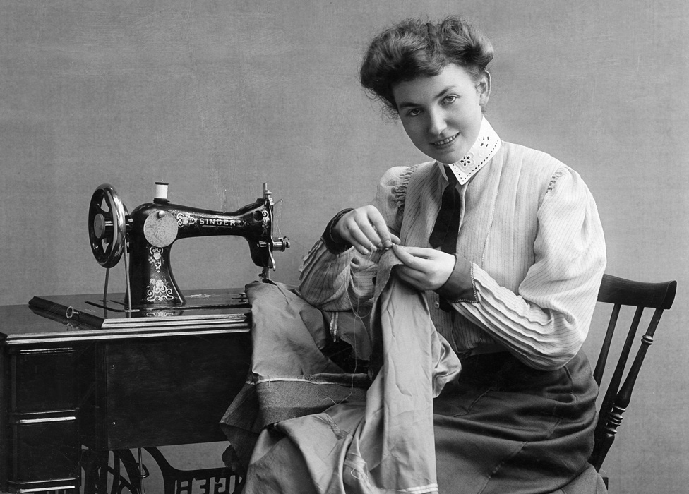 A seamstress using a Singer sewing machine in 1907
