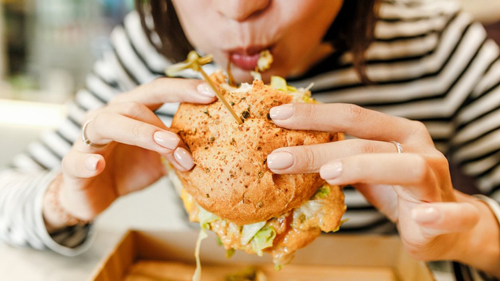 Una mujer come una hamburguesa.,