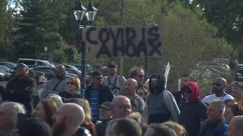 Протестующие держат плакат с надписью «Covid - это обман»