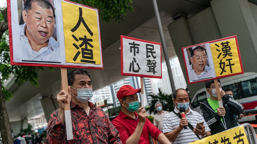 親北京示威者在香港西九龍法院大樓外舉起辱罵黎智英的標語牌（資料圖片）