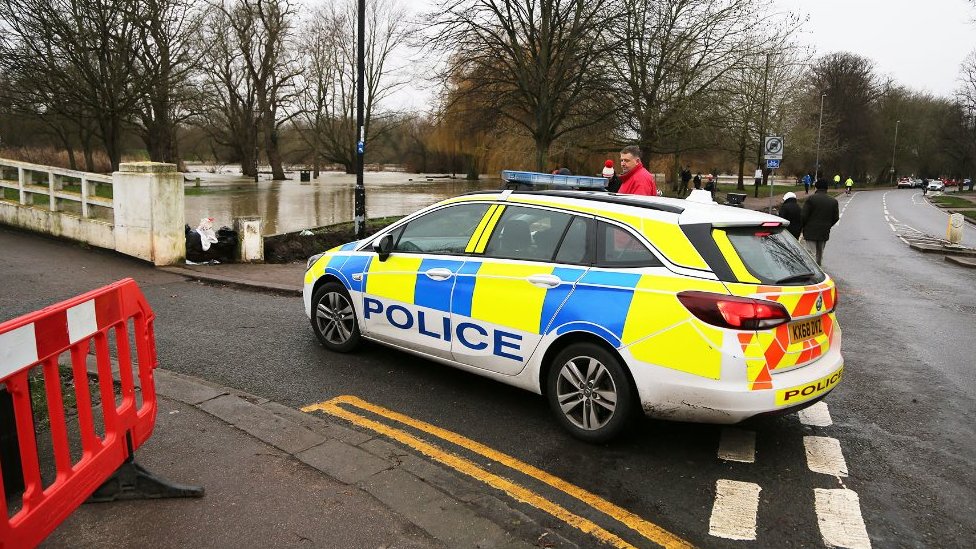 A police car next to high water levels in Bedford