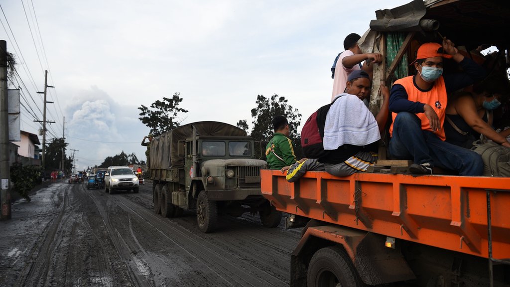 Жители на борту правительственного грузовика эвакуируются в более безопасное место после того, как вулкан Таал начал извергать пепел над городом Танауан, провинция Батангас к югу от Манилы 13 января || |