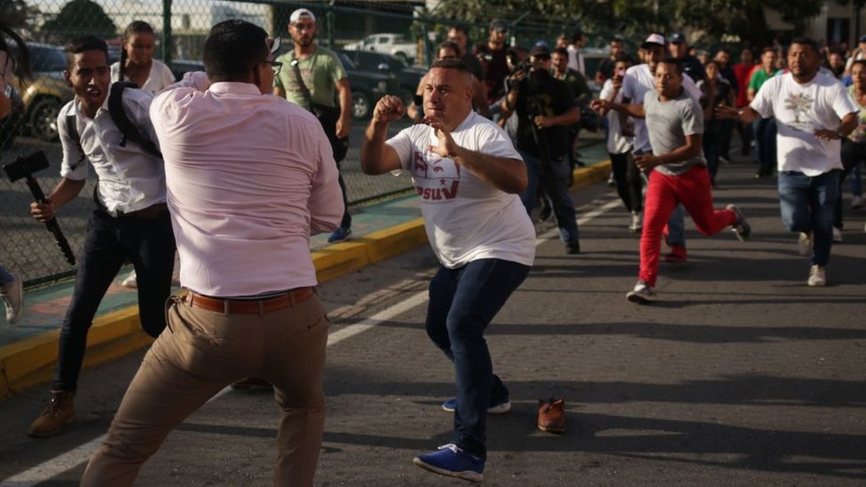Un partidario de Maduro (centro) confronta a un periodista (segundo a la izquierda) tras la llegada de Guaidó al estado de Vargas.