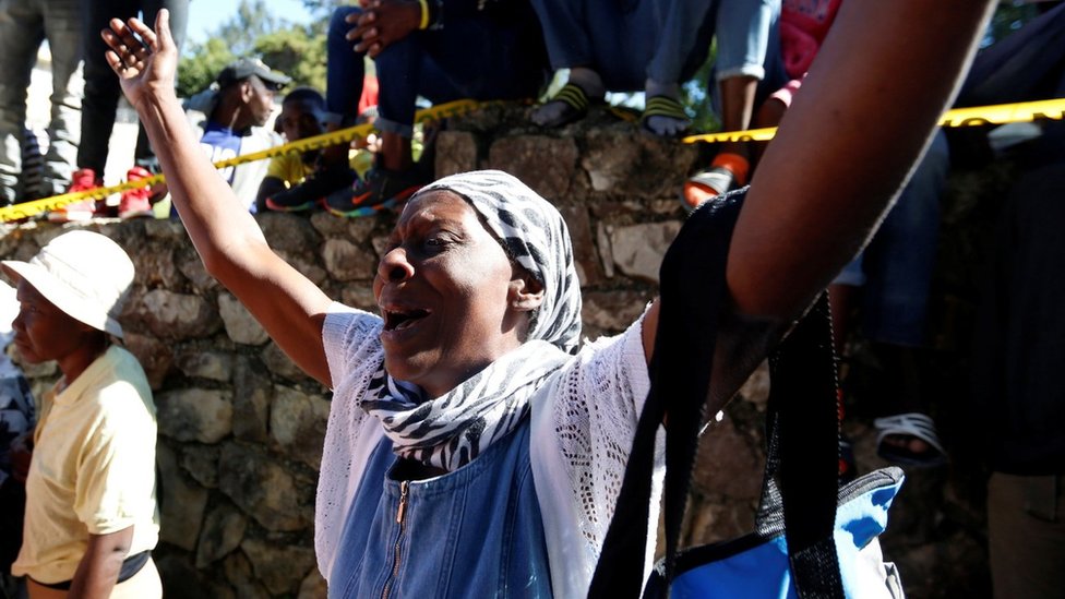 Una mujer reacciona con una expresión de dolor en el lugar donde se incendió el orfanato.