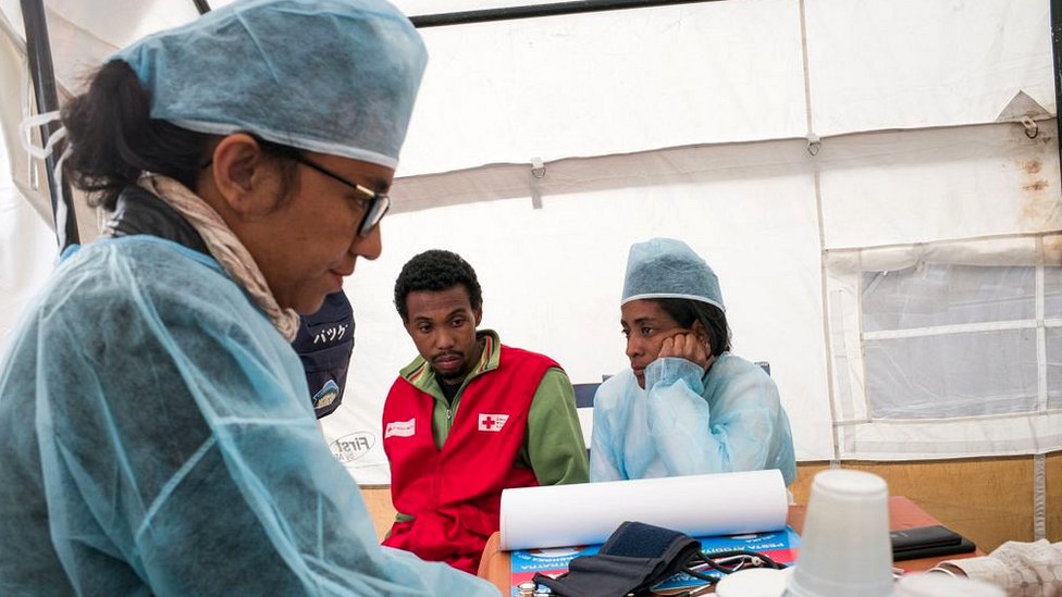 Este brote tardó tiempo en identificarse y en ese tiempo la peste proliferó sin control. Doctora atiende a dos pacientes en carpa sanitaria