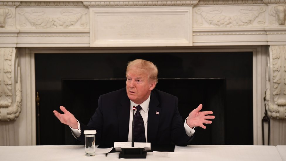 Trump fala e gesticula sentado em sala de reunião na Casa Branca