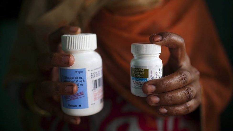 A woman holding antiretroviral drugs in India