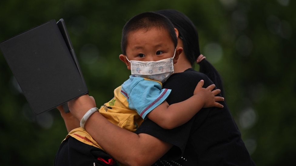A mother holds his son next to Yangtze River in Wuhan, in Chinas central Hubei province on May 12, 2020. -