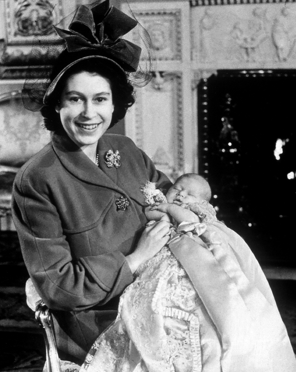 Su majestad la reina Isabel II fotografiada cuando era la princesa Isabel, con su primer bebé (el rey Carlos III) en su bautizo en 1948.
