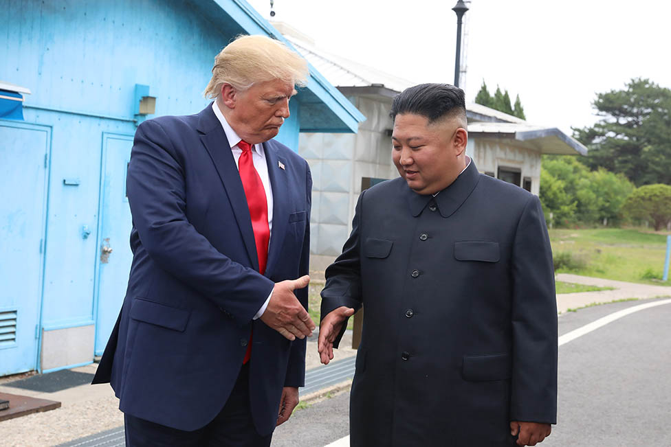 El ex presidente Donald Trump y el líder norcoreano Kim Jong-un se estrechan la mano.