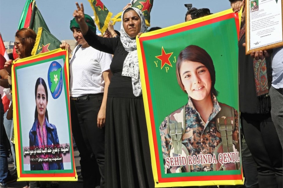 Курдские демонстранты машут своими национальными флагами и держат фотографии курдского политического лидера Хеврина Халафа (слева), который, как сообщается, был убит поддерживаемыми Турцией ополченцами, и Сехид Рожинда Кендил, курдский боец, убитый в Сирии, во время демонстрации против последнего турецкого военного наступления. на северо-востоке Сирии, на площади Мучеников в центре Бейрута, 13 октября 2019 г.