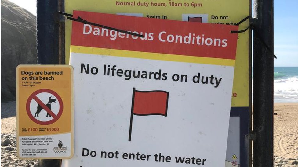 Таблички в Chapel Porth предупреждают посетителей пляжа об отсутствии спасателей из RNLI