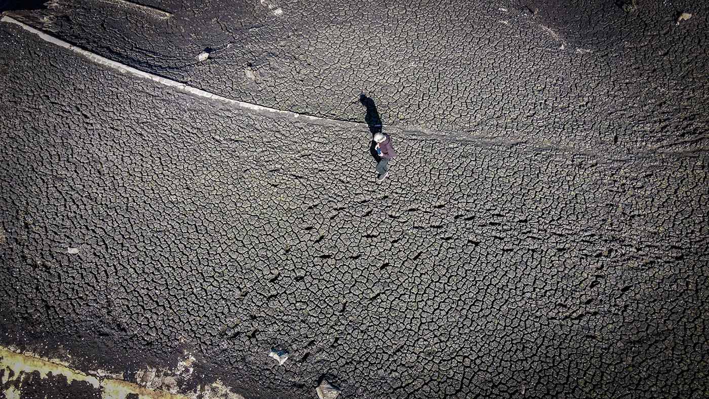 A person walks across a dry area of drought-hit Paso Severino reservoir, in Canelones, Uruguay - 8 July 2023