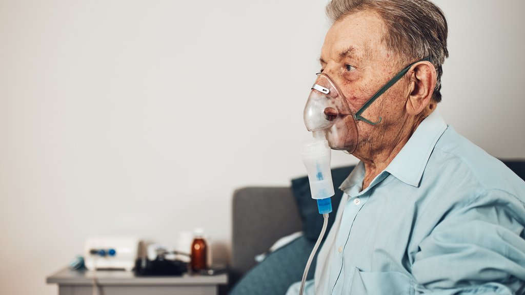 Un anciano recibiendo oxígeno.