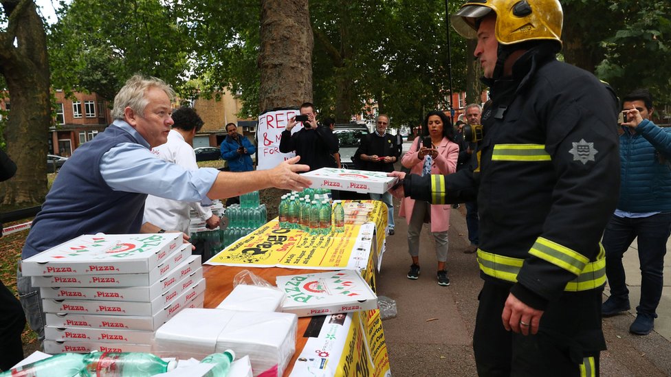 Un restaurante de la zona acudió al lugar para regalar comida y agua a los equipos de emergencia trabajando tras la explosión. El dueño de un restaurante italiano regala pizza y agua a los equipos de emergencia tras la explosión en el metro de Londres.