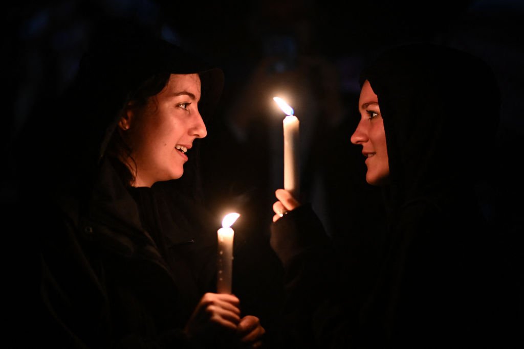 Ciudadanos sostienen velas a las afueras del Palacio de Buckingham