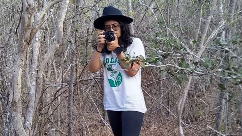 Sabrina Oliveira holds a camera